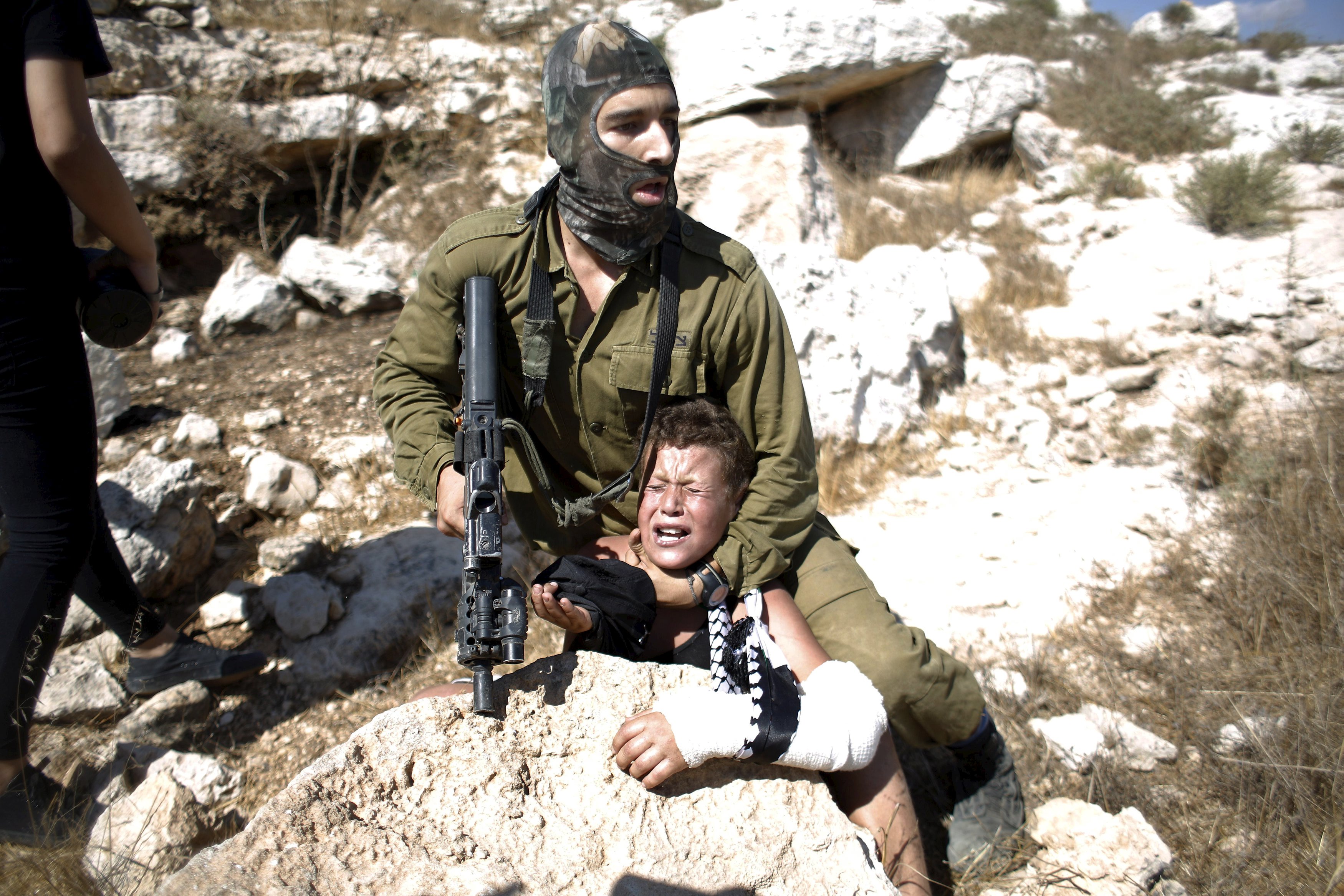 An Israeli soldier detains a Palestinian boy during a protest against Jewish settlements in the West Bank village of Nabi Saleh, near Ramallah August 28, 2015. REUTERS/Mohamad Torokman 